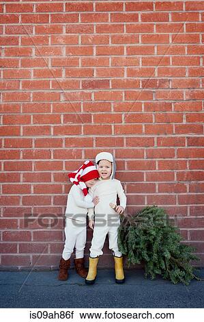 Stock Image - Brother and sister picking christmas tree. Fotosearch