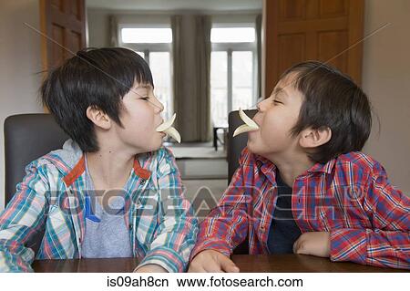 Brothers imitating bird beak with crisps View Large Photo Image Picture - Brothers imitating bird beak with crisps. Fotosearch