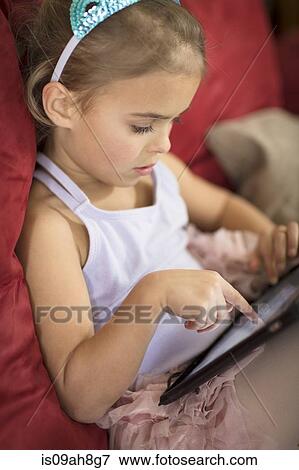 Stock Photo - Close up of young girl using touchscreen on digital tablet. Fotosearch