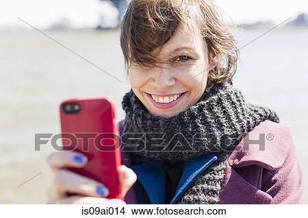 Picture - Close up portrait of young woman with smartphone. Fotosearch