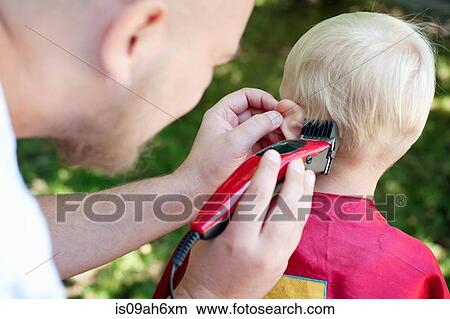 Picture - Father cutting toddler sons hair with clippers. Fotosearch