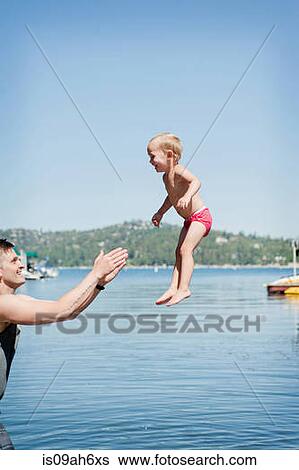 Female toddler being caught mid air by father View Large Photo Image Stock Photograph - Female toddler being caught mid air by father. Fotosearch