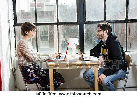 Male and female designers working on laptops in studio View Large Photo Image Picture - Male and female designers working on laptops in studio. Fotosearch