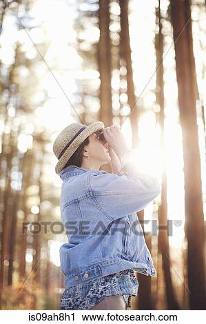 Mature female bird watching in forest View Large Photo Image Stock Image - Mature female bird watching in forest. Fotosearch
