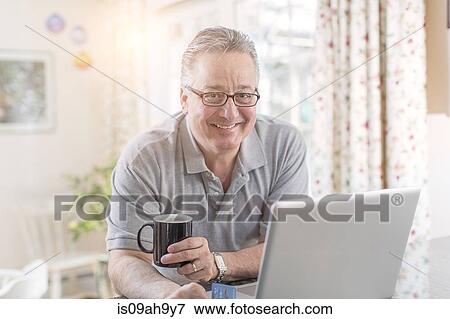 Mature man at home using laptop View Large Photo Image Stock Photo - Mature man at home using laptop. Fotosearch
