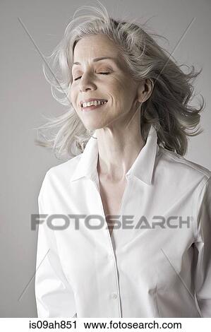 Mature woman smiling, eyes closed View Large Photo Image Stock Image - Mature woman smiling, eyes closed. Fotosearch