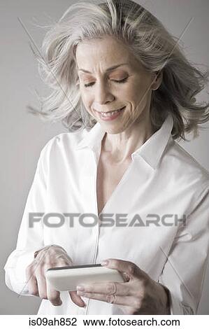 Mature woman using smartphone View Large Photo Image Stock Image - Mature woman using smartphone. Fotosearch