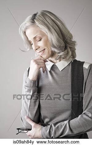 Mature woman with hand on chin, smiling View Large Photo Image Stock Photo - Mature woman with hand on chin, smiling. Fotosearch