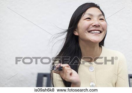 Mid adult woman holding eyeglasses and smiling View Large Photo Image Stock Photo - Mid adult woman holding eyeglasses and smiling. Fotosearch