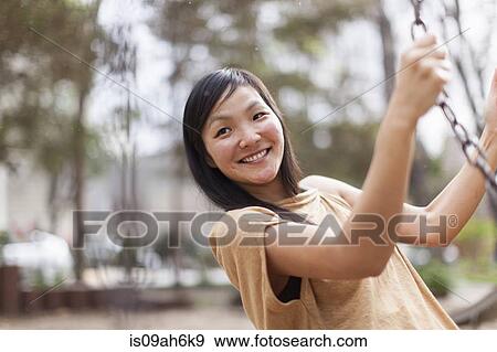 Mid adult woman swinging in city park View Large Photo Image Stock Photo - Mid adult woman swinging in city park. Fotosearch