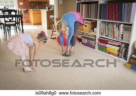 Stock Image - Mother and young daughter warming up for ballet. Fotosearch