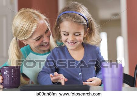 Mother and young daughter with digital tablet View Large Photo Image Picture - Mother and young daughter with digital tablet. Fotosearch