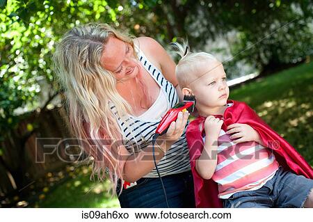 Mother cutting toddler sons hair with clippers View Large Photo Image Picture - Mother cutting toddler sons hair with clippers. Fotosearch