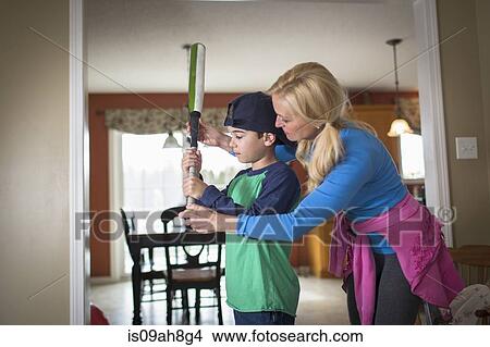 Mother teaching son to hold a baseball bat View Large Photo Image Picture - Mother teaching son to hold a baseball bat. Fotosearch