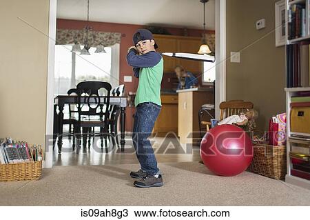 Portrait of boy practicing baseball in sitting room View Large Photo Image Stock Image - Portrait of boy practicing baseball in sitting room. Fotosearch