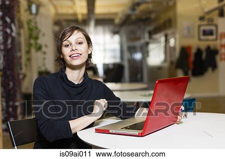 Portrait of female designer with red laptop View Large Photo Image Stock Image - Portrait of female designer with red laptop. Fotosearch