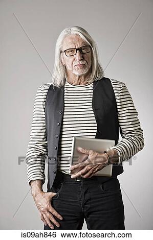 Stock Photograph - Portrait of mature man, holding digital tablet. Fotosearch