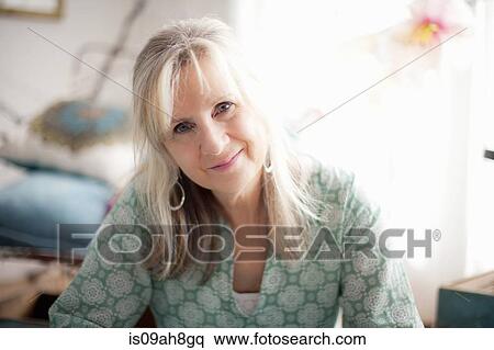Stock Photography - Portrait of mature woman in sitting room. Fotosearch