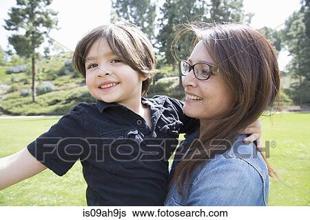 Stock Photograph - Portrait of mother and son in park. Fotosearch