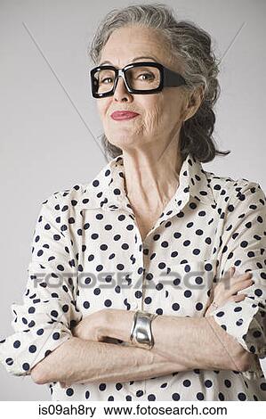Stock Photo - Portrait of senior woman, arms crossed. Fotosearch
