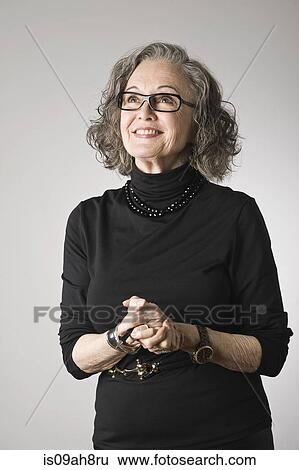 Stock Photograph - Portrait of senior woman, looking up. Fotosearch