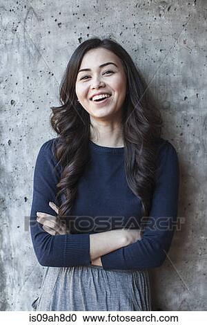 Portrait of young woman, arms folded View Large Photo Image Stock Image - Portrait of young woman, arms folded. Fotosearch