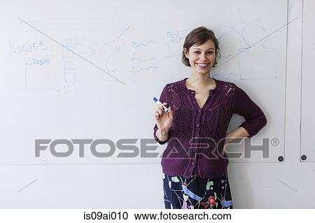 Stock Image - Portrait of young woman in front of whiteboard. Fotosearch