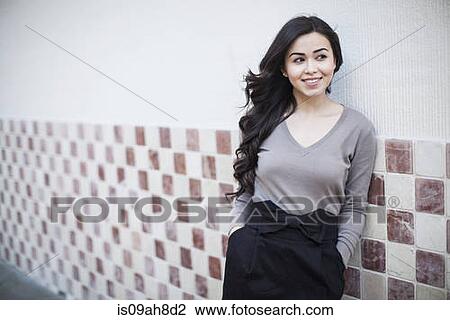 Portrait of young woman, leaning against tiled wall View Large Photo Image Stock Image - Portrait of young woman, leaning against tiled wall. Fotosearch