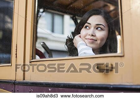 Portrait of young woman, looking through window of cable car View Large Photo Image Stock Image - Portrait of young woman, looking through window of cable car. Fotosearch