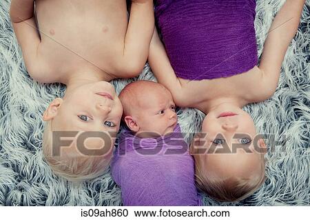 Siblings lying on carpet View Large Photo Image Stock Image - Siblings lying on carpet. Fotosearch