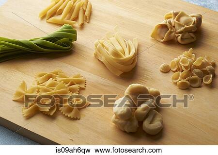 Stock Photo - Still life of chopping board with a variety of raw pasta. Fotosearch