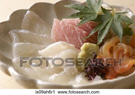 Stock Image - Still life of raw fish dish with leaves. Fotosearch