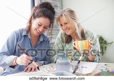 Stock Photo - Two mature female artists painting in studio. Fotosearch