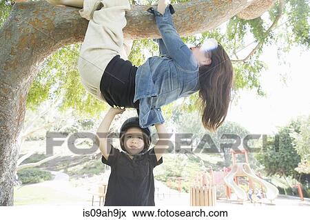 Upside down mother wrapped around tree branch with son helping View Large Photo Image Stock Photo - Upside down mother wrapped around tree branch with son helping. Fotosearch