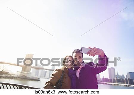 Young couple photographing themselves, New York, USA View Large Photo Image Stock Image - Young couple photographing themselves, New York, USA. Fotosearch