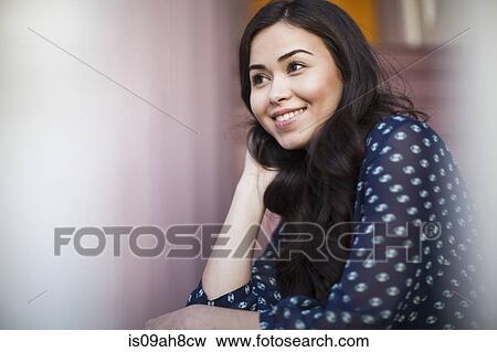 Stock Photo - Young woman smiling and looking away. Fotosearch