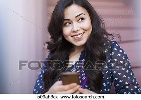 Young woman using smartphone View Large Photo Image Stock Photo - Young woman using smartphone. Fotosearch