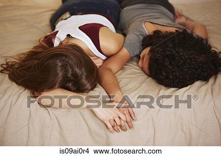 Picture - Affectionate young female couple sleeping on bed. Fotosearch