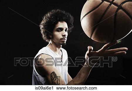 Basketball player balancing basketball on finger View Large Photo Image Stock Image - Basketball player balancing basketball on finger. Fotosearch