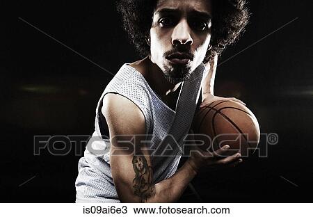 Stock Image - Basketball player holding basketball. Fotosearch