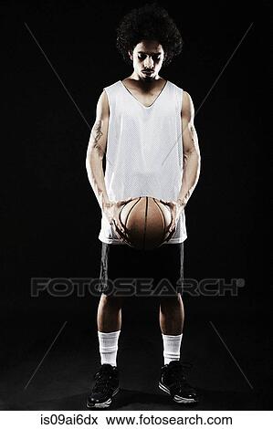 Stock Photo - Basketball player holding basketball. Fotosearch