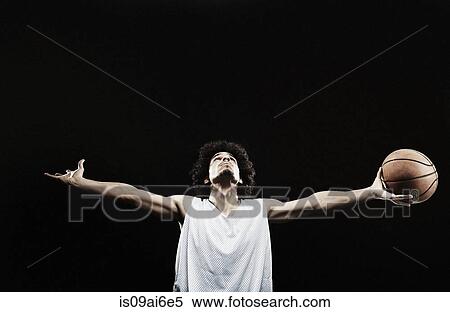 Stock Photography - Basketball player holding basketball with arms out. Fotosearch