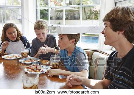 Picture - Boy balancing pizza box on head. Fotosearch