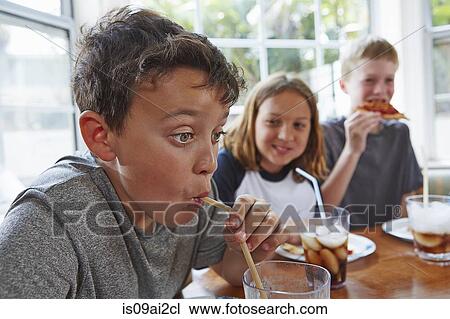 Boy drinking soft drink through straw View Large Photo Image Stock Image - Boy drinking soft drink through straw. Fotosearch