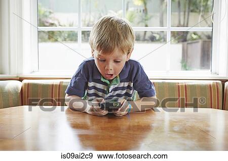 Boy playing handheld video game View Large Photo Image Stock Photo - Boy playing handheld video game. Fotosearch
