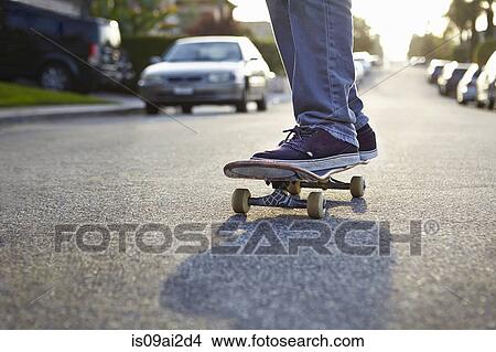 Boy skateboarding on road, close up View Large Photo Image Picture - Boy skateboarding on road, close up. Fotosearch