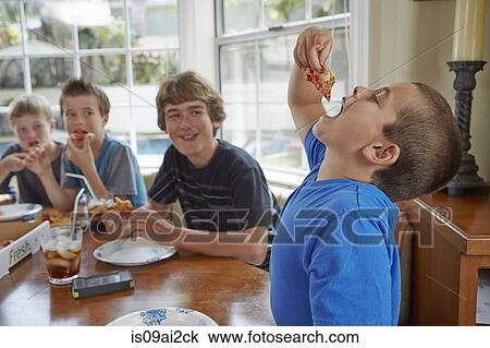 Stock Image - Boy swallowing pizza with mouth open. Fotosearch