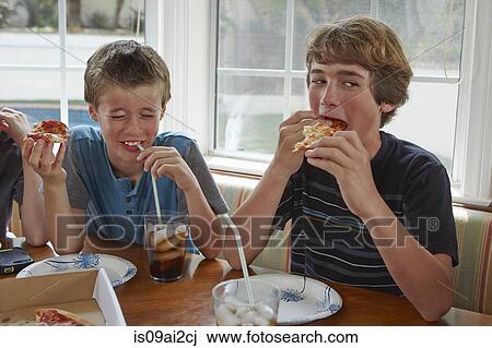 Stock Image - Boys eating pizza. Fotosearch