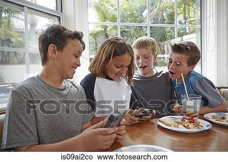 Picture - Boys playing handheld video games. Fotosearch