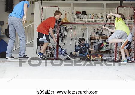 Boys playing hockey in garage View Large Photo Image Stock Photography - Boys playing hockey in garage. Fotosearch